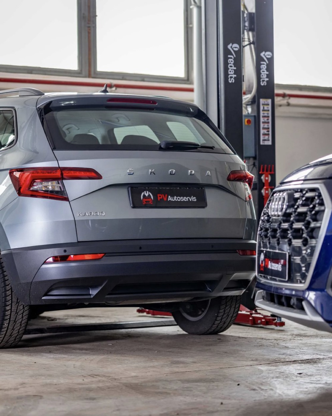 Škoda Karoq s tabuľkou PV Autoservis v dielni